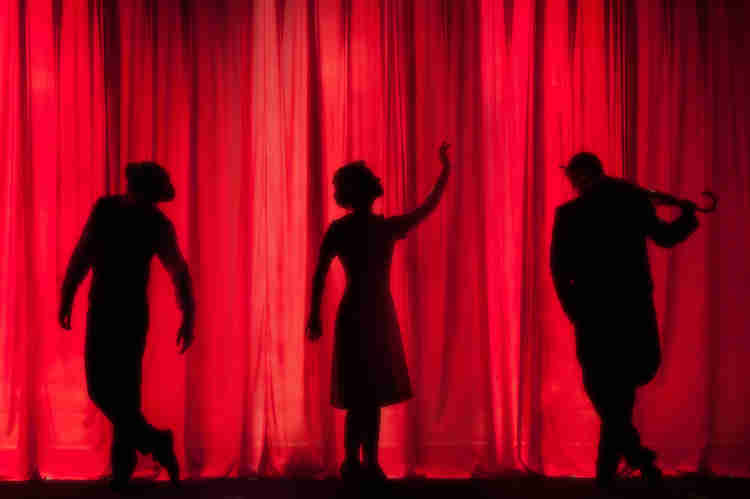 Shadow dancer behind a giant red curtain.