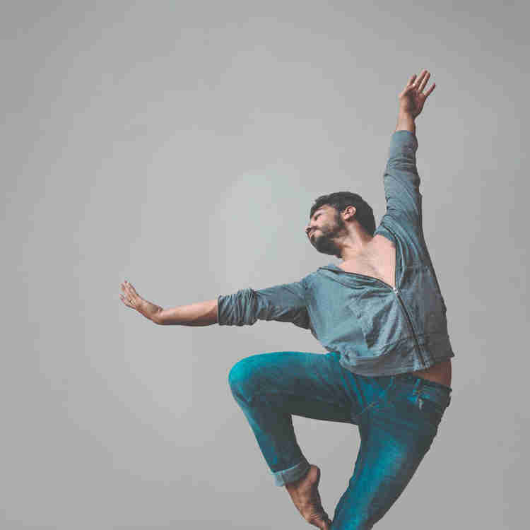 Male modern dancer posing to the left direction on passe.
