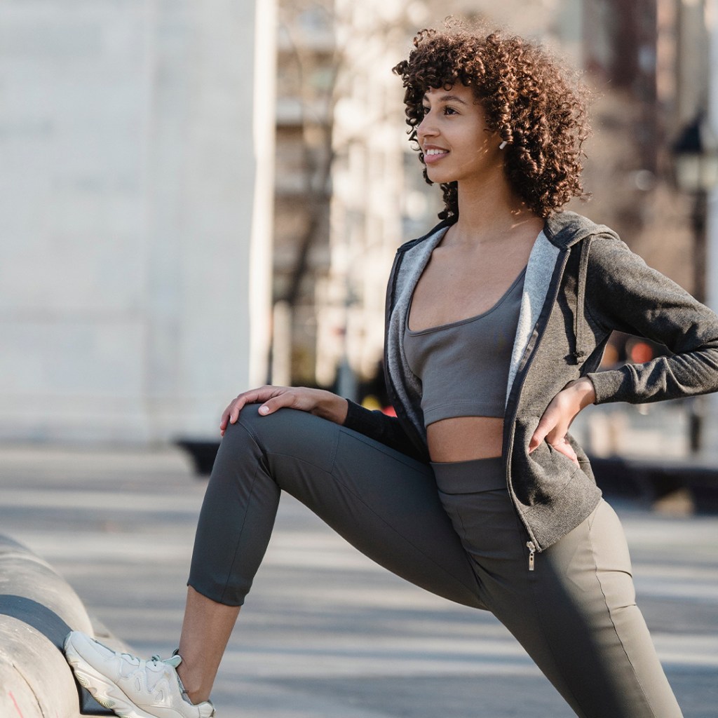 Dancer gaming up and stretching at park before an outdoor class.