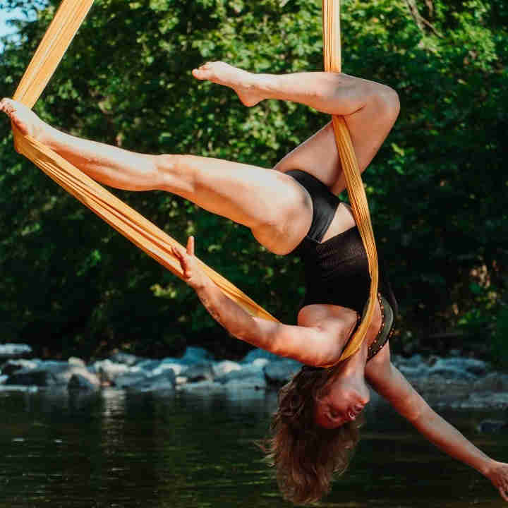 Aerial silks dancer dancing over a lake.
